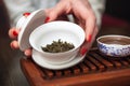 Woman holding chawan with green oolong.