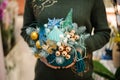 Woman holding a Christmas composition in marine style made of fir tree, glass balls, seashell, sea star, mask and beads