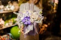 Woman holding a christmas composition with purple and white orchids and roses, tapes and candles in the box Royalty Free Stock Photo