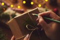 Woman holding Christmas gift and writes Royalty Free Stock Photo