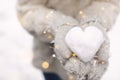 Woman holding Christmas lights and heart made of snow