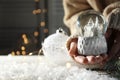 Woman holding Christmas snow globe on blurred background. Space for text Royalty Free Stock Photo