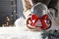 Woman holding Christmas snow globe with red bow Royalty Free Stock Photo