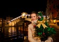 Woman holding Christmas tree near Rialto Bridge in Venice, Italy Royalty Free Stock Photo