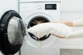 Woman holding clean white pillow in front of the drum of washing machine Royalty Free Stock Photo