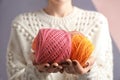 Woman holding clews of knitting threads