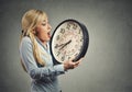 Woman holding clock looking anxiously, running out of time Royalty Free Stock Photo