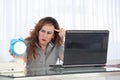 Woman holding a clock. Red-haired woman holds an alarm clock in her hand in the workplace