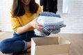 Woman holding Clothes with Donate Box In her room Donation Concept