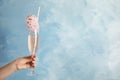 Woman holding cocktail with  cotton candy on blue background, closeup. Space for text Royalty Free Stock Photo