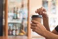 A woman is holding a coffee cup in coffee`s shop at noon