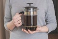 Woman is holding a coffee in a French press