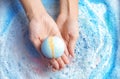 Woman holding color bath bomb over foam Royalty Free Stock Photo