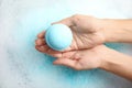 Woman holding color bath bomb over foam Royalty Free Stock Photo