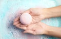 Woman holding color bath bomb over foam Royalty Free Stock Photo