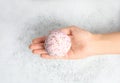Woman holding color bath bomb over foam Royalty Free Stock Photo