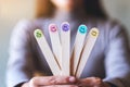 A woman holding hand draw happy emotion faces on wooden stick