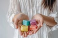 woman holding colorful shampoo bars on a white background