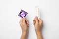 Woman holding condom and birth control pills on background, top view. Safe sex Royalty Free Stock Photo