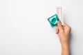 Woman holding condom and birth control pills on white, top view. Safe sex Royalty Free Stock Photo