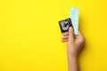 Woman holding condom and birth control pills on yellow, top view with space for text. Safe sex Royalty Free Stock Photo