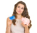 Woman holding credit card and piggy bank