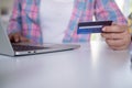 Woman holding a credit card to pay for goods through an application on a laptop. Online shopping and payment on internet banking Royalty Free Stock Photo