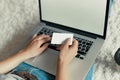 Woman holding credit card and working on a laptop Female using a laptop sitting on floor Royalty Free Stock Photo