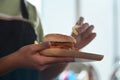 Woman holding fish burger and eating fried potatoes. Royalty Free Stock Photo