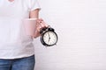 Woman holding a cup of coffee and alarm clock showing 7 am in hands, ready for work concept, copy space Royalty Free Stock Photo