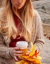 Woman holding cup of coffee in the hands outdoor. Beautiful woman drinking coffee in autumn park Royalty Free Stock Photo