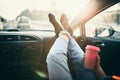 Woman is holding cup of coffee inside of car