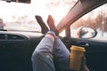 Woman is holding cup of coffee inside of car