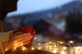 Woman holding cup of hot beverage on balcony decorated with Christmas lights, closeup with space for text Royalty Free Stock Photo