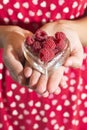 Woman holding a cup of raspberries Royalty Free Stock Photo