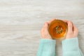 Woman holding cup of tasty herbal tea with thyme at white wooden table, closeup. Space for text Royalty Free Stock Photo