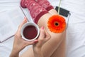 Woman holding a cup of tea in bed Royalty Free Stock Photo