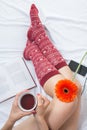 Woman holding a cup of tea in bed Royalty Free Stock Photo