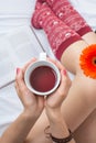 Woman holding a cup of tea in bed Royalty Free Stock Photo