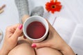 Woman holding a cup of tea in bed Royalty Free Stock Photo