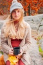 Woman holding cup of tea in the hands outdoor in autumn park Royalty Free Stock Photo