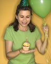 Woman holding cupcake.