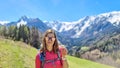 Matschacher Gupf - A woman holding daisies in her hand with panoramic view on Baeren Valley in Austrian Alps Royalty Free Stock Photo