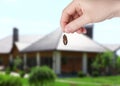 Woman holding dead cockroach and blurred view of modern house on background. Pest control