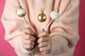 Woman holding delicious Christmas cake pops on pink background, closeup Royalty Free Stock Photo
