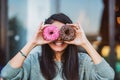 Woman is holding delicious and colored donuts with humor Royalty Free Stock Photo