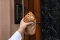 Woman holding delicious croissant near door, closeup Royalty Free Stock Photo