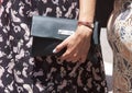 A woman holding a designer clutch purse