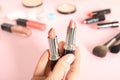 Woman holding different lipsticks over color table Royalty Free Stock Photo