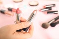 Woman holding different lipsticks over color table. Space for text Royalty Free Stock Photo